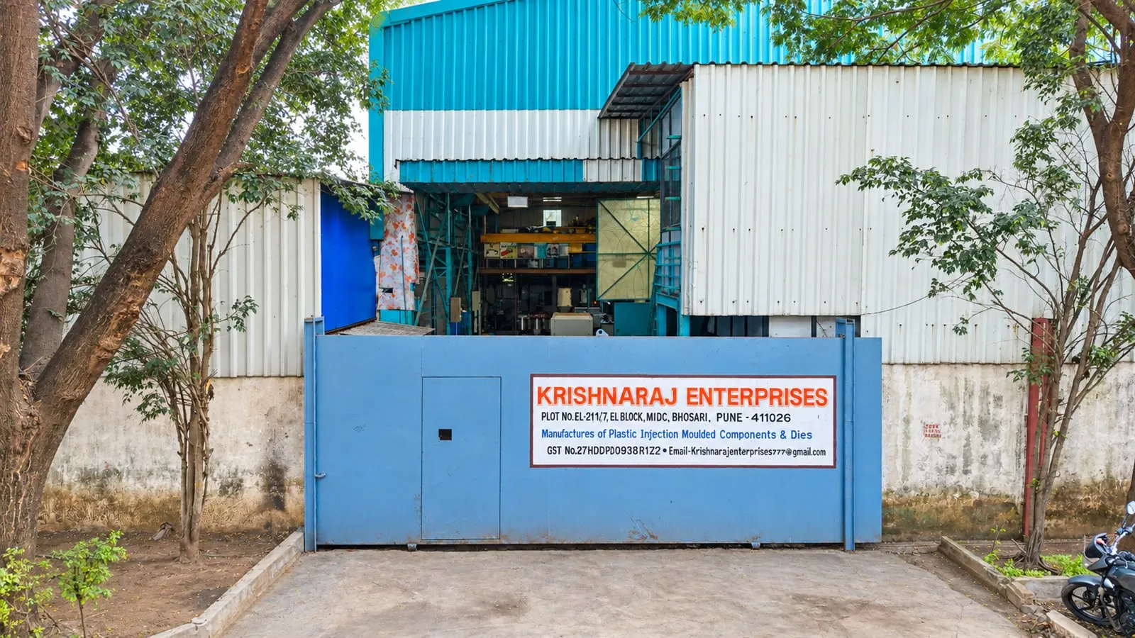 Front gate of the Krishnaraj Enterprises plant, with the company name, GST number and &lsquo;Manufacturers of Plastic Injection Moulded Components & Dies&rsquo; on the gate sign