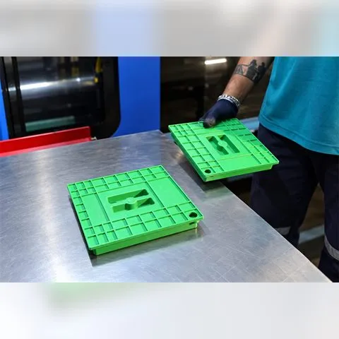 Green moulded ribbed panels beside the moulding machine