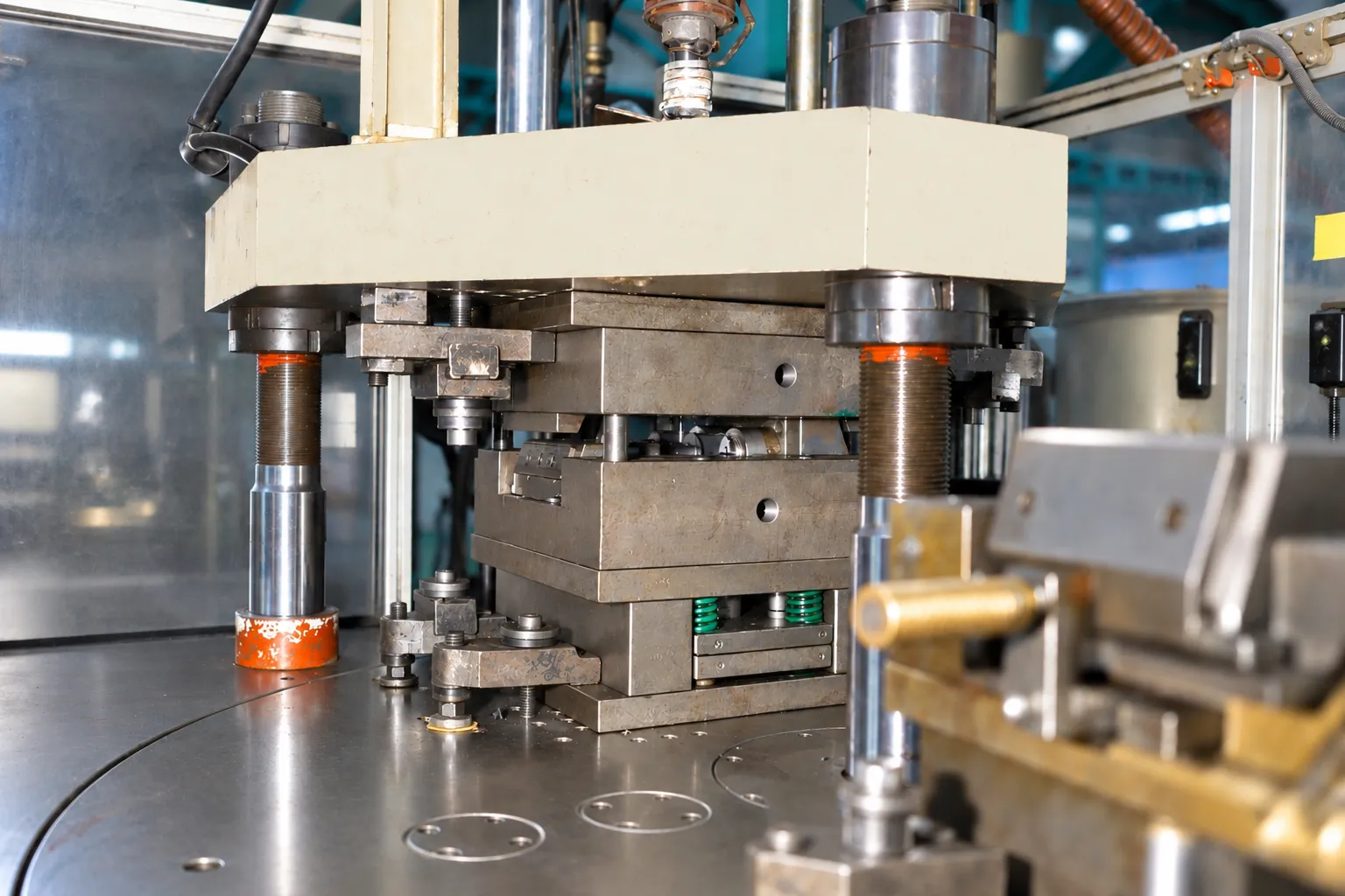 Close view of the vertical press tooling area used for insert loading